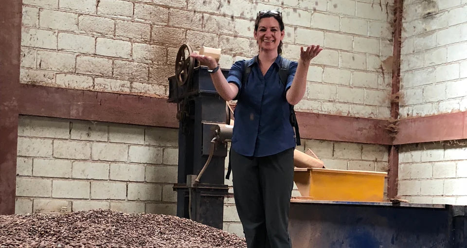 Person standing next to a machine in an industrial setting with a brick wall background